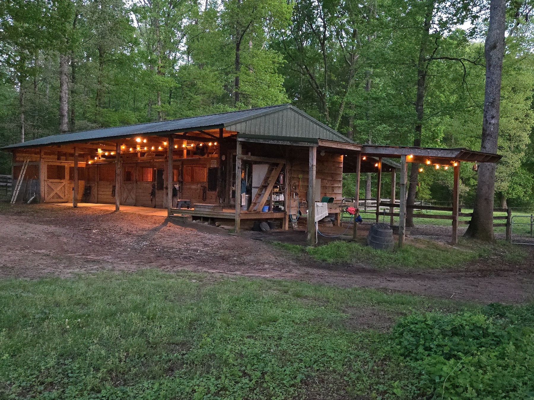 Horse barn at Flying Changes Farm with lights on at dusk